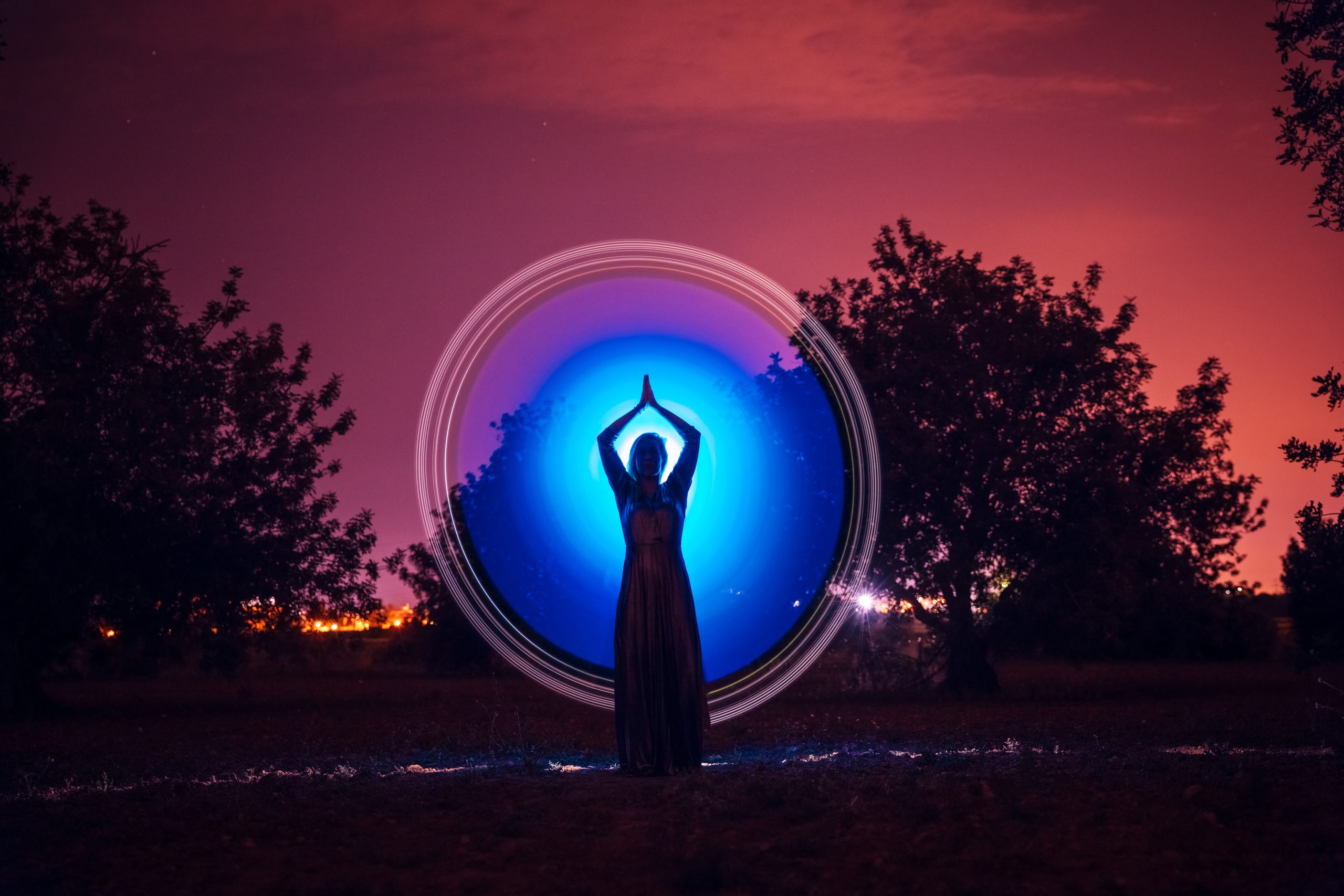 Female silhouette in glowing circle in nature
